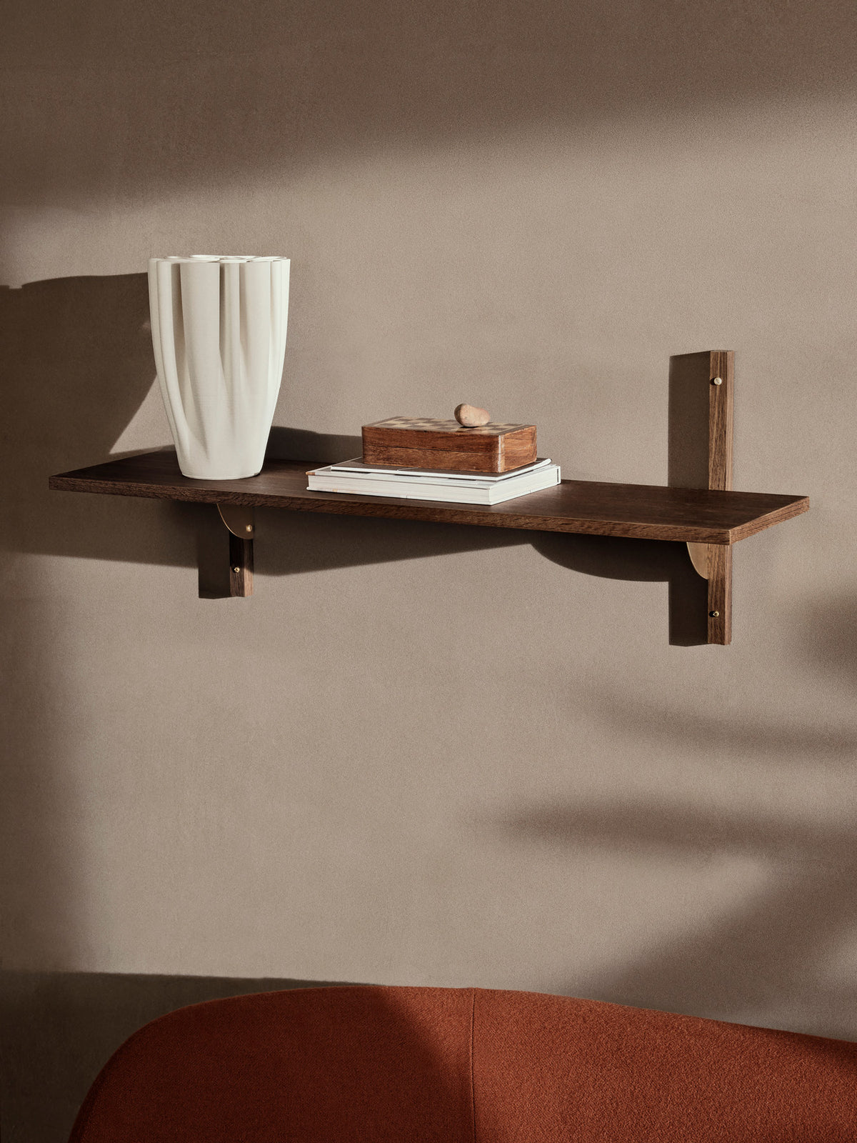 Sector Wandregal von Ferm Living in Smoked Oak/Brass: Eichenfurnier mit Profilen aus massiver Eiche und Halterungen aus Messing, an der Wand montiert.