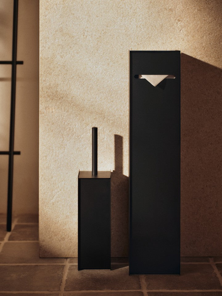 Eleganter Sama Toilettenpapierhalter in Schwarz von Ferm Living, stilvoll präsentiert in einem modernen Badezimmer-Setting.