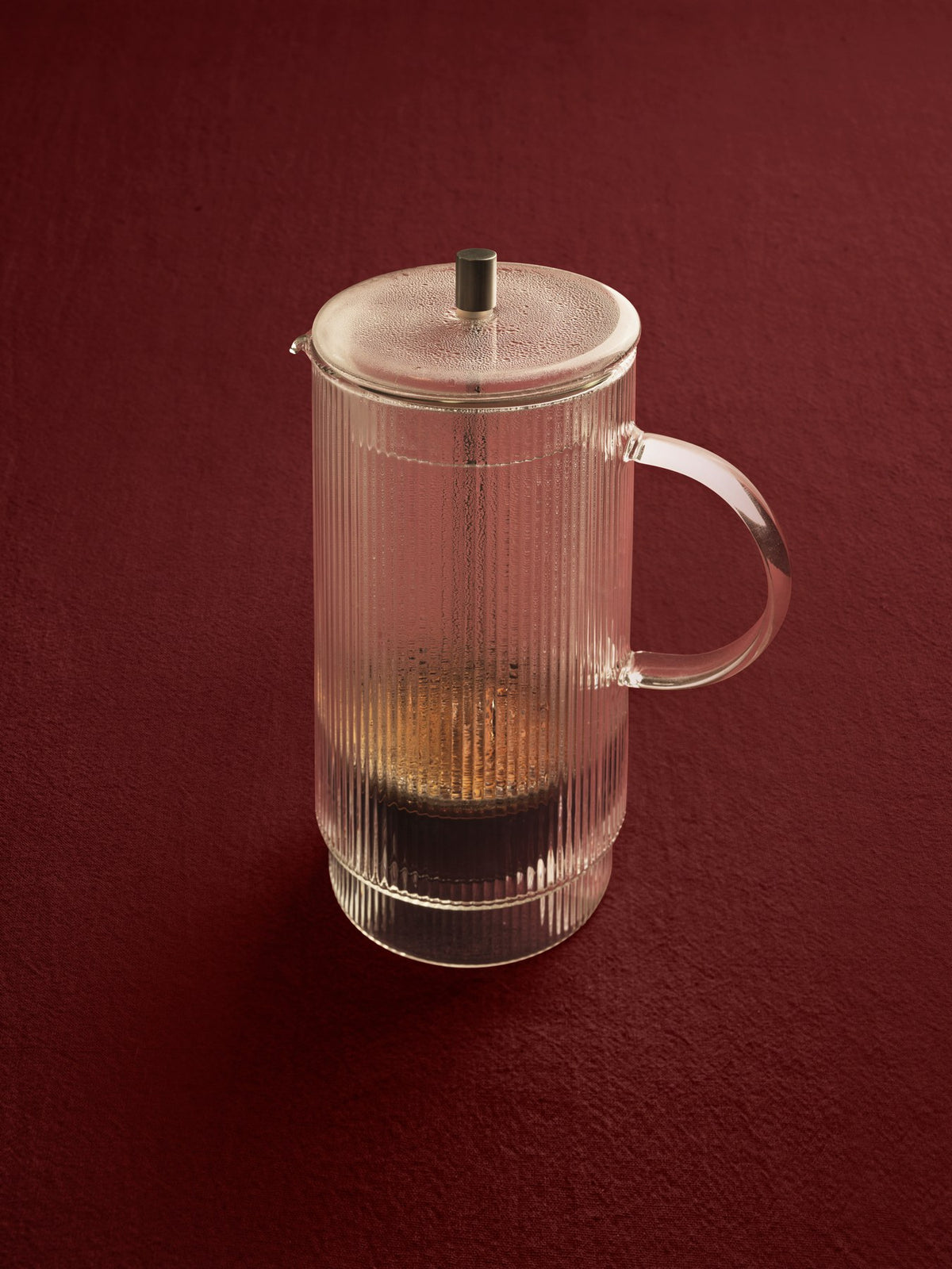 Doppelwandige French Press aus mundgeblasenem Glas mit geriffelter Oberfläche und Edelstahl-Deckel, transparent, zylindrische Form.