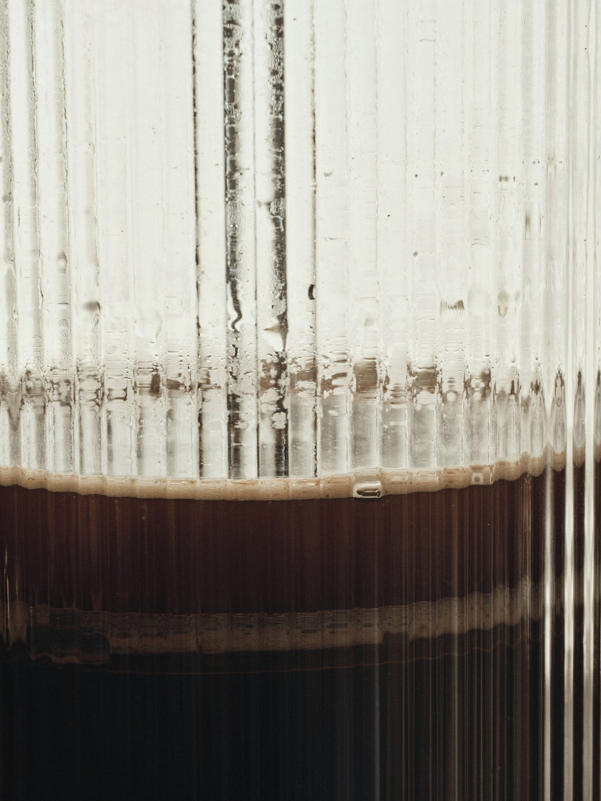 Doppelwandige French Press aus mundgeblasenem Glas mit geriffelter Oberfläche und Edelstahl-Deckel, transparent, zylindrische Form.