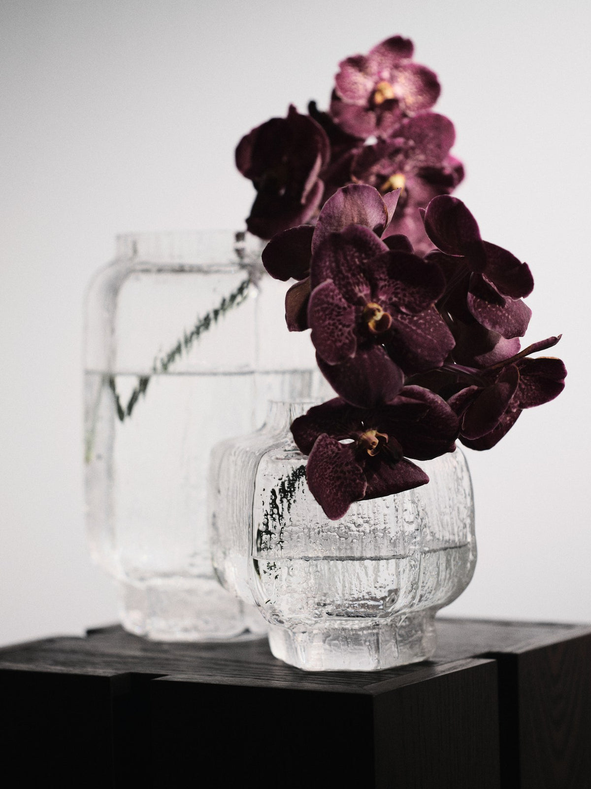 Schwarze Mokuri Vase aus mundgeblasenem, recyceltem Glas mit facettierter Oberfläche und vertikalen Linien, Höhe 15 cm.