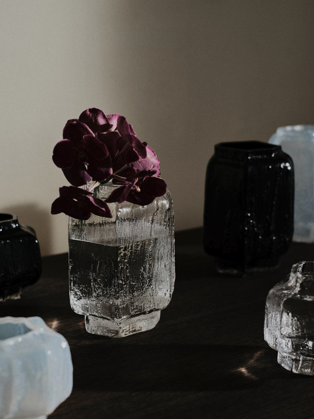 Schwarze Mokuri Vase aus mundgeblasenem, recyceltem Glas mit facettierter Oberfläche und vertikalen Linien, Höhe 15 cm.