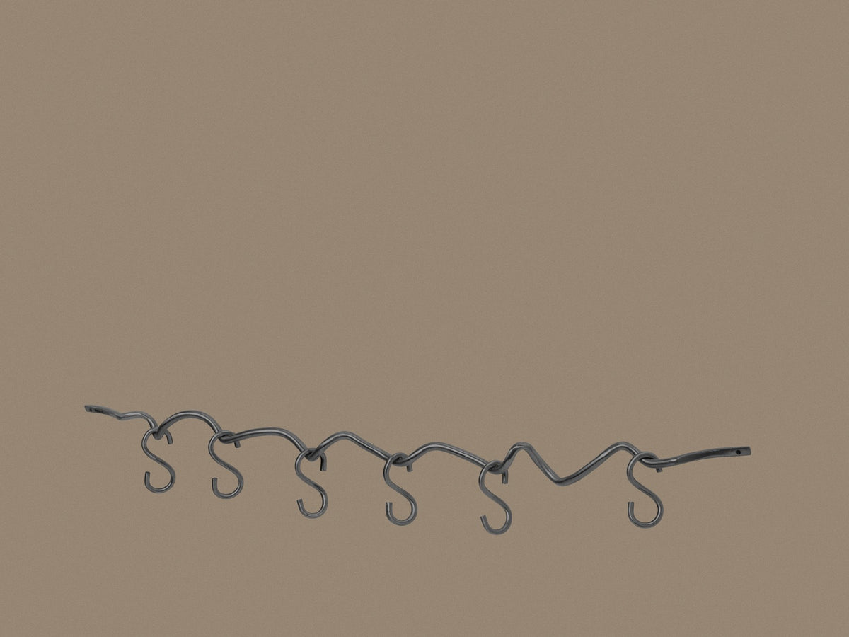 Produktfoto der Curvature Hängestange von Ferm Living aus massivem Messing mit matter Politur, inklusive sechs Haken, geschwungene Form.