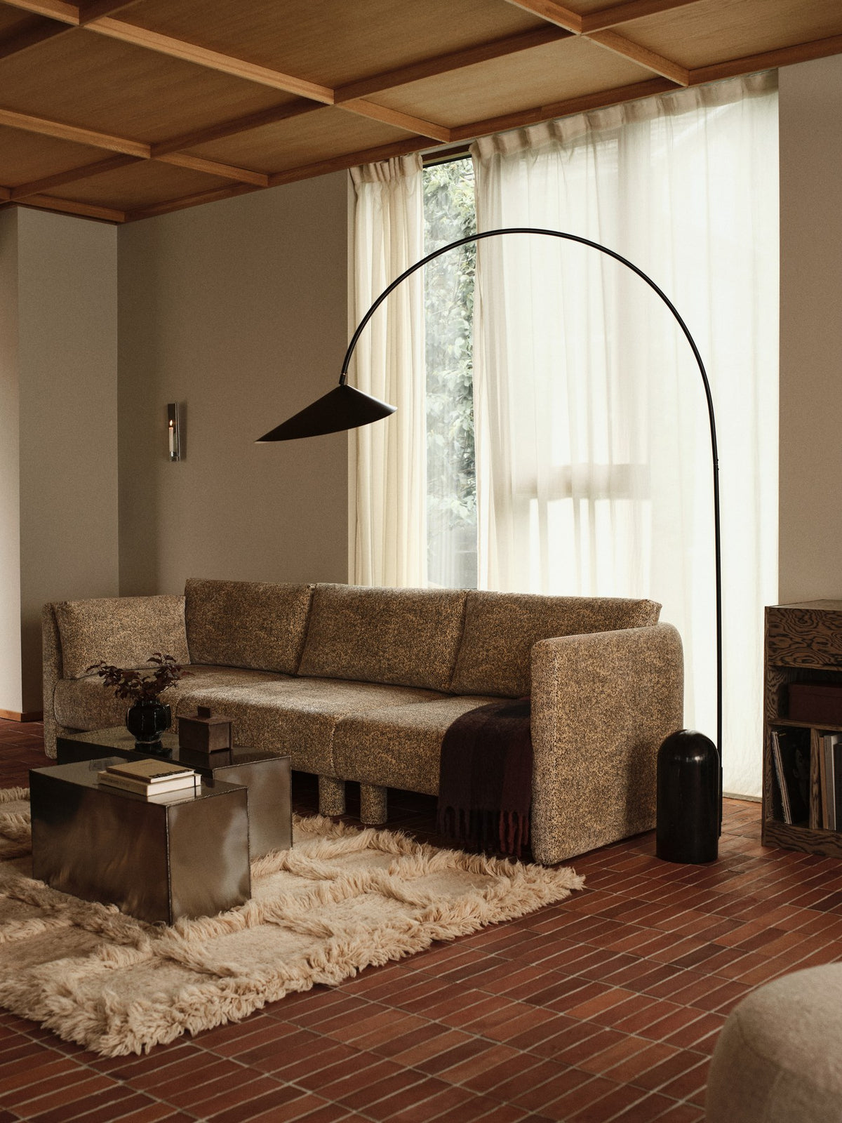 Ferra Couchtisch von Ferm Living aus gebürstetem Edelstahl mit sichtbaren, handverschweissten Kanten und leicht geschwungener Form.