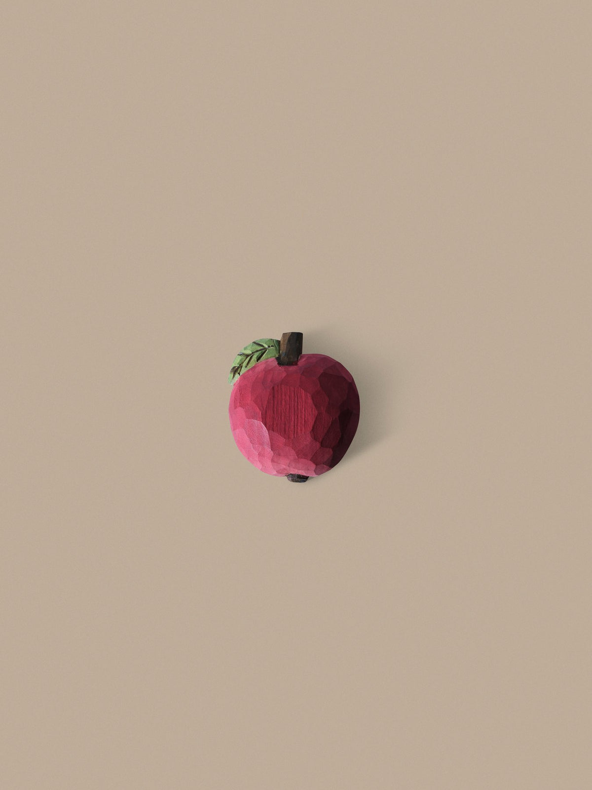 Kleiderhaken Apple von Ferm Living, handgeschnitzt und handbemalt aus FSC-zertifiziertem Espenholz, in der Farbe Mohnrot, mit sichtbarer Holzmaserung.