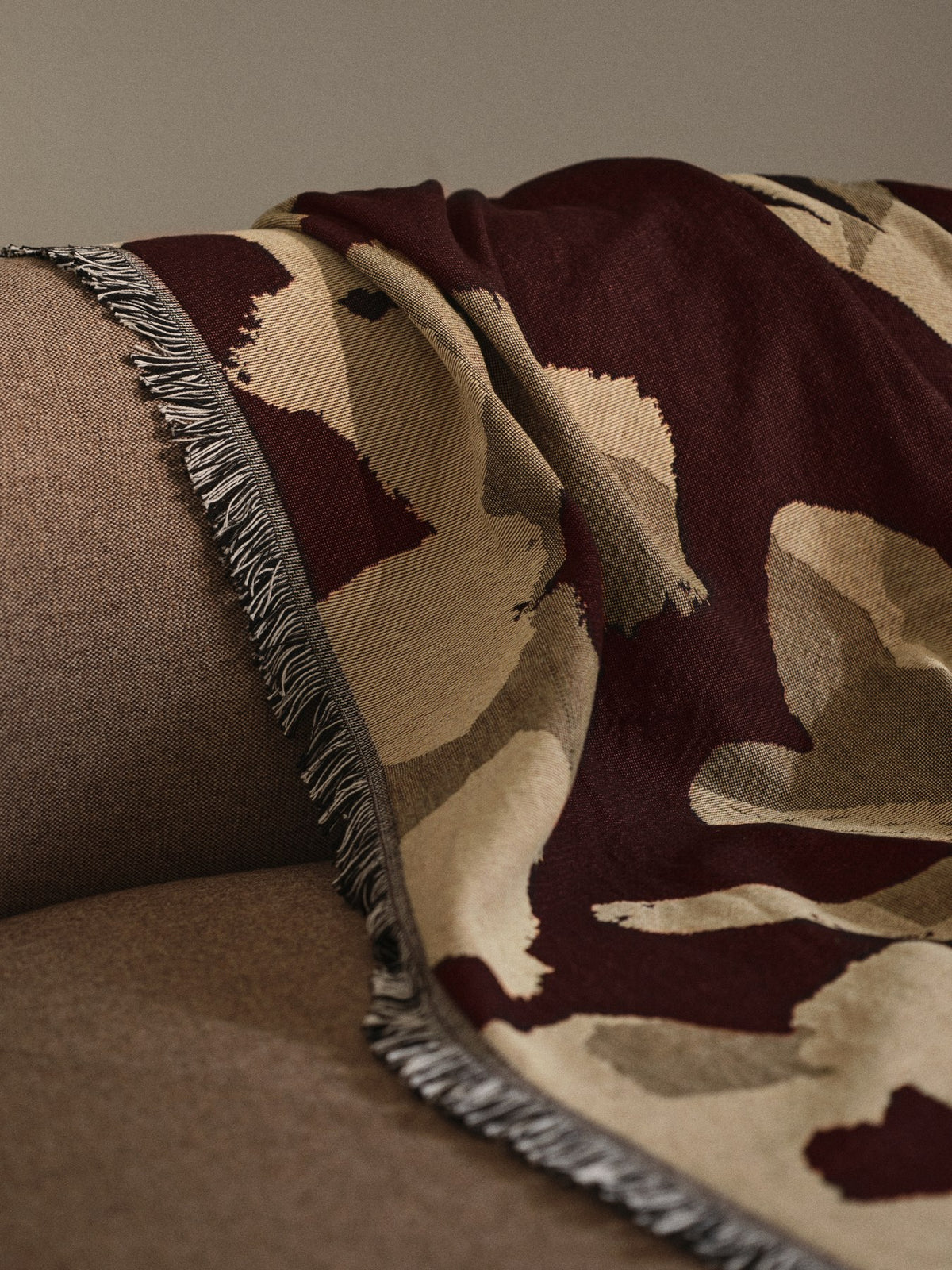 Cilla Wanddecke von Ferm Living in Dunkel Pecan aus 100% Bio-Baumwolle mit handgewebtem Blumenmotiv, Fransen und Tapisserie-Webstruktur.