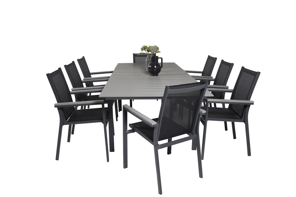 Rechteckiger Esstisch aus Aintwood mit Aluminiumgestell in Anthrazit, dazu zwei stapelbare Stühle mit pulverbeschichteter Oberfläche.