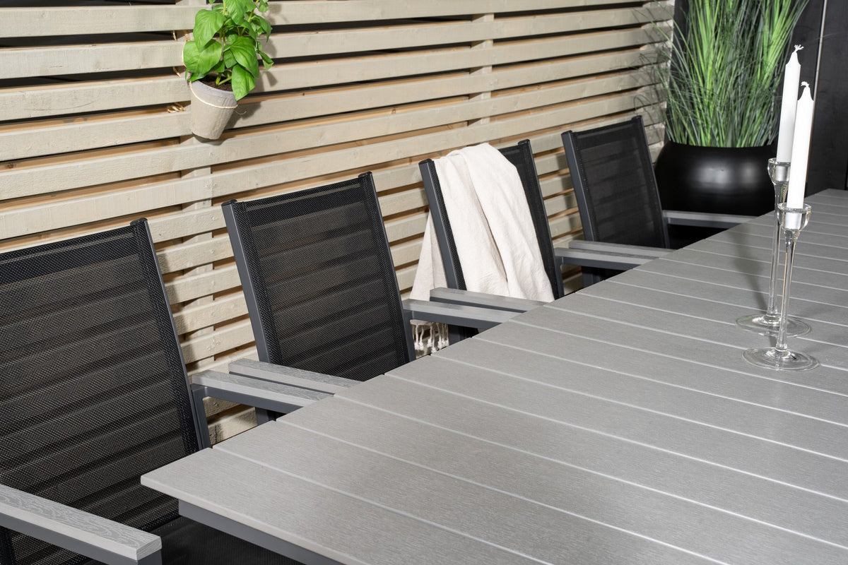 Rechteckiger Esstisch aus Aintwood mit Aluminiumgestell in Anthrazit, dazu zwei stapelbare Stühle mit pulverbeschichteter Oberfläche.