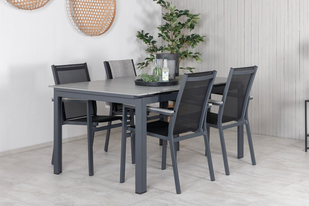 Rechteckiger Esstisch aus Aintwood mit Aluminiumgestell in Anthrazit, dazu zwei stapelbare Stühle mit pulverbeschichteter Oberfläche.
