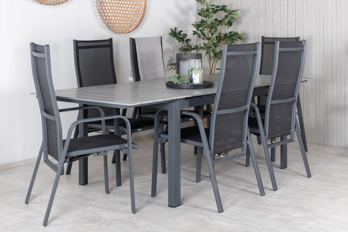 Schwarzer ausziehbarer Gartentisch Levels mit grauer Aintwood-Tischplatte und zwei stapelbaren Copacabana Sesseln aus Aluminium und Aintwood.