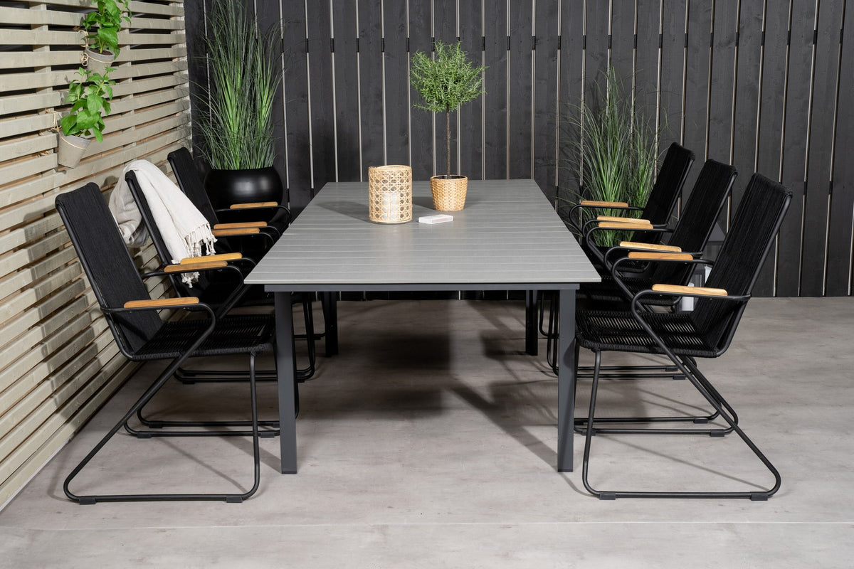 Schwarzer rechteckiger Gartentisch aus Aintwood und Aluminium mit grauer Tischplatte, dazu zwei schwarze Esszimmerstühle mit Pulverbeschichtung.