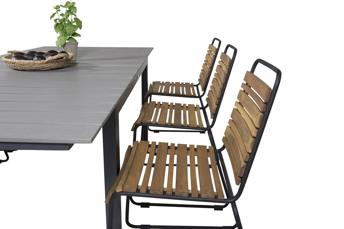 Rechteckiger Gartentisch mit grauer Aintwood-Tischplatte und schwarzem Stahlgestell, daneben zwei Esszimmerstühle aus Aintwood und Aluminium in Natur.