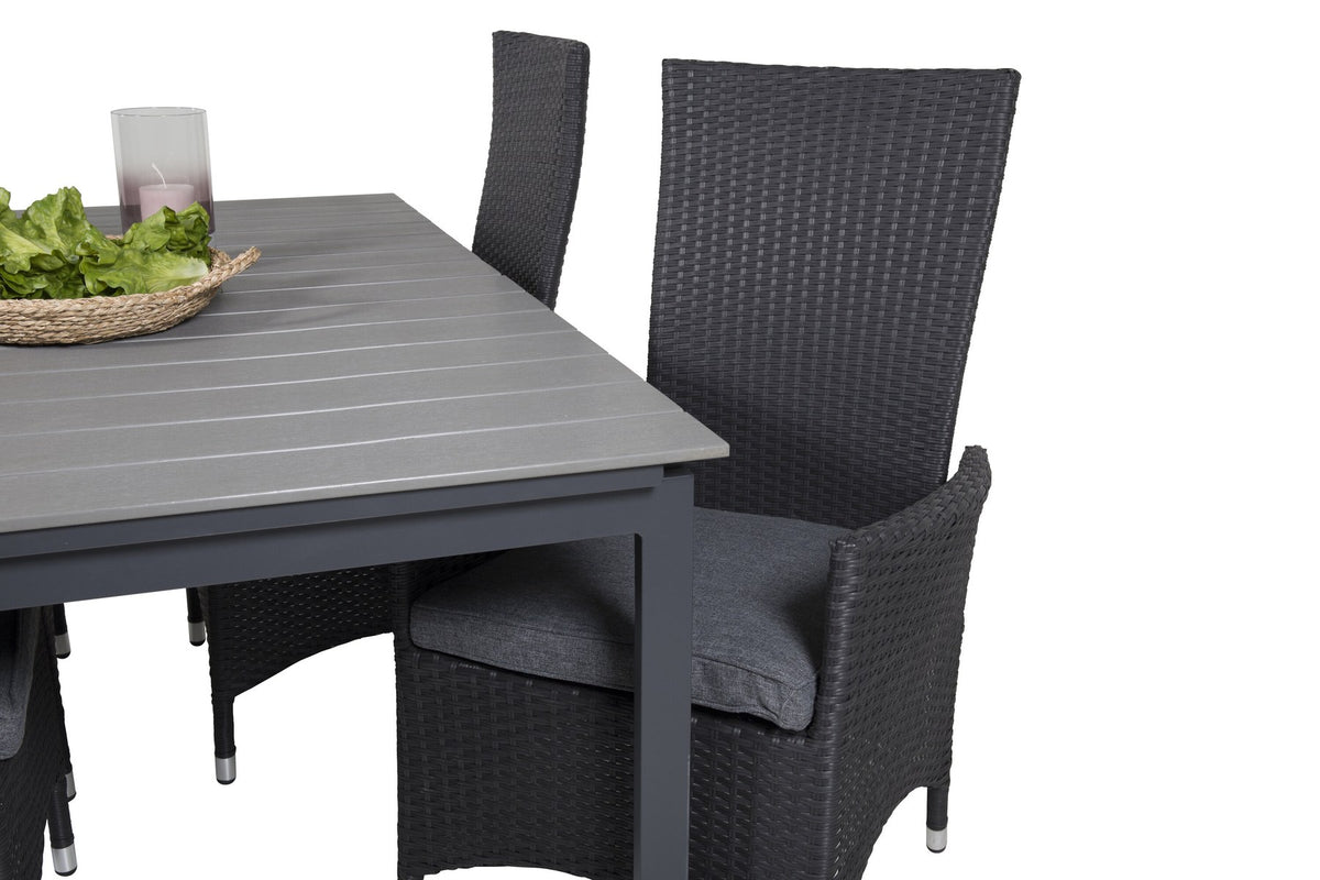 Foto eines rechteckigen Esstischs mit grauer Aintwood-Tischplatte und Aluminiumbeinen sowie zwei schwarzen Relaxsesseln mit Polyesterbezug im Garten.