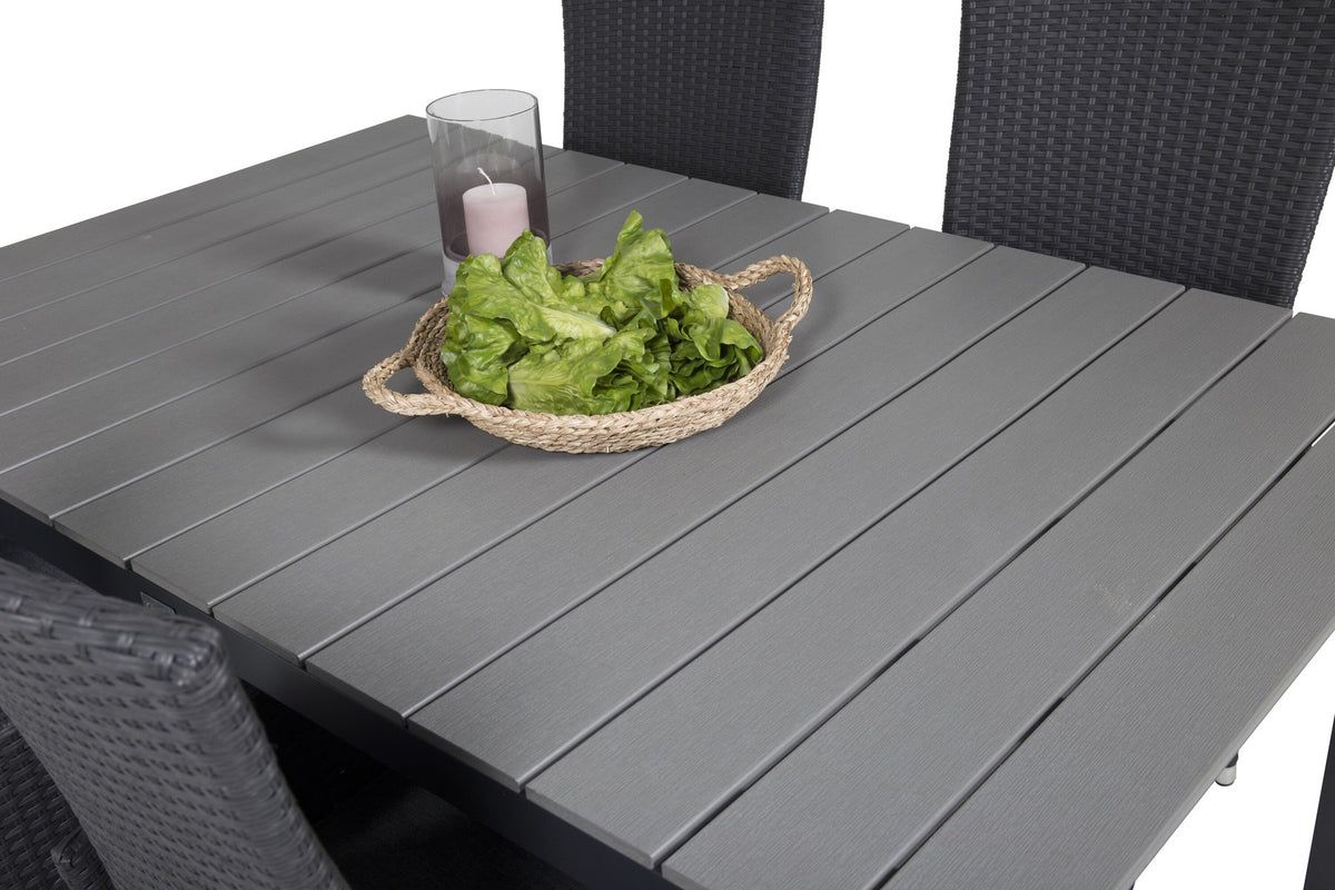 Foto eines rechteckigen Esstischs mit grauer Aintwood-Tischplatte und Aluminiumbeinen sowie zwei schwarzen Relaxsesseln mit Polyesterbezug im Garten.
