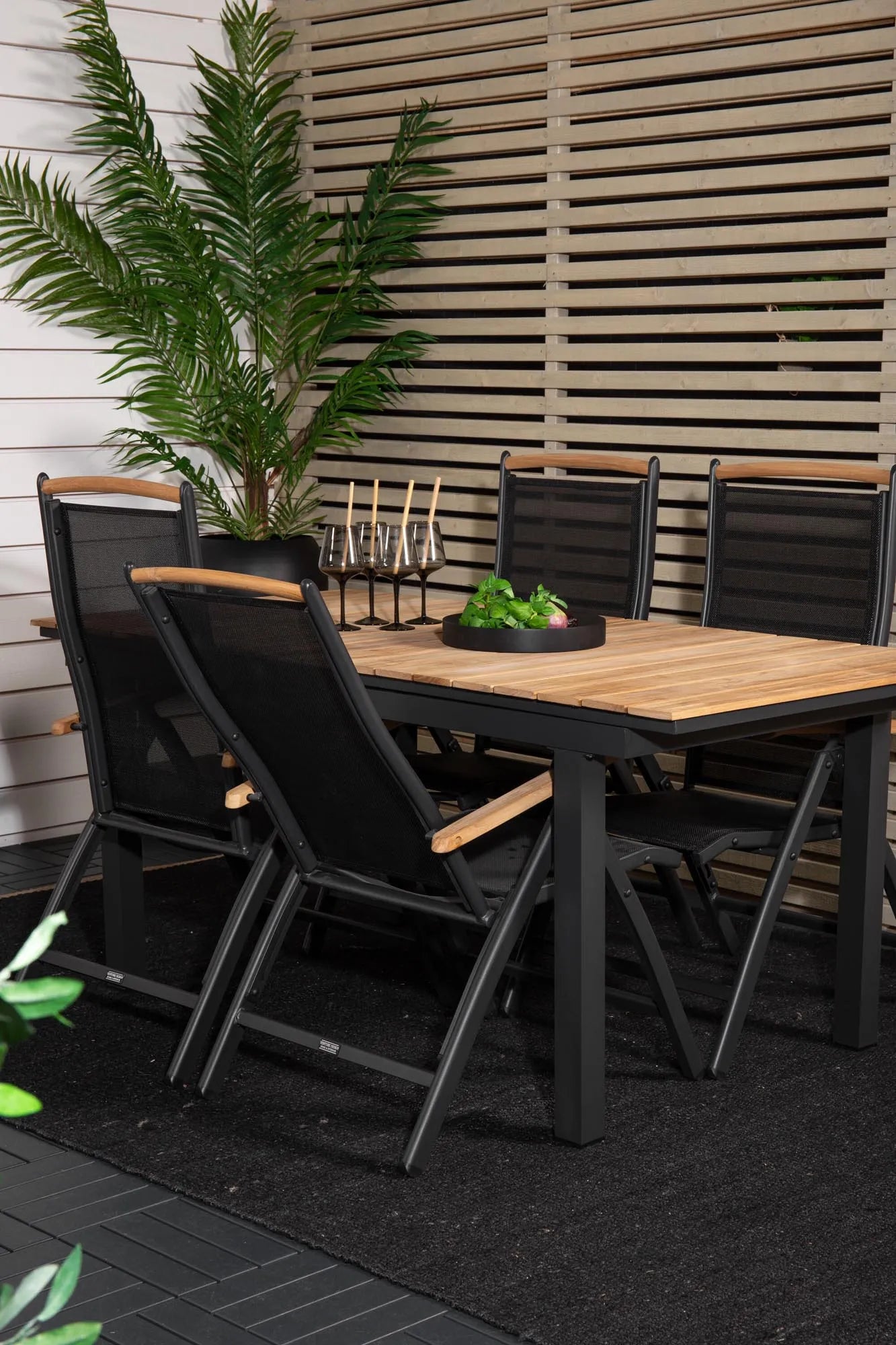Eleganter Teakholz-Gartentisch, ausziehbar, wetterfest, mit klappbaren Stühlen für stilvolle Outdoor-Dinner.