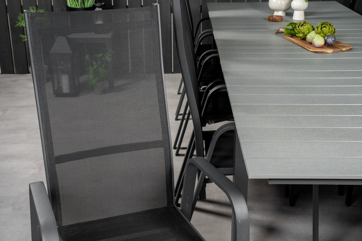 Rechteckiger Gartentisch mit grauer Aintwood-Platte und Aluminiumgestell, daneben zwei stapelbare Copacabana-Relaxsessel in Schwarz.