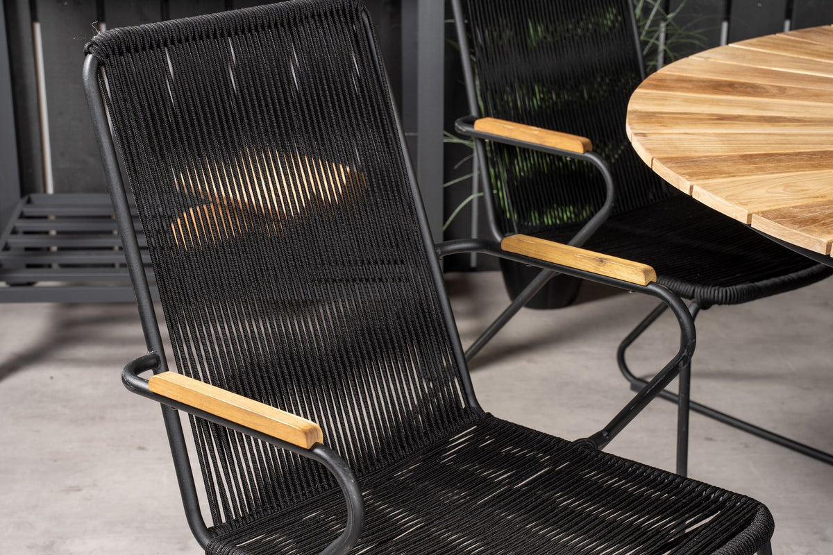 Runder Gartentisch mit Teak-Tischplatte in Naturfarbe, Stahlbeinen und Stühlen mit schwarzer Seilbespannung im Aussenbereich.