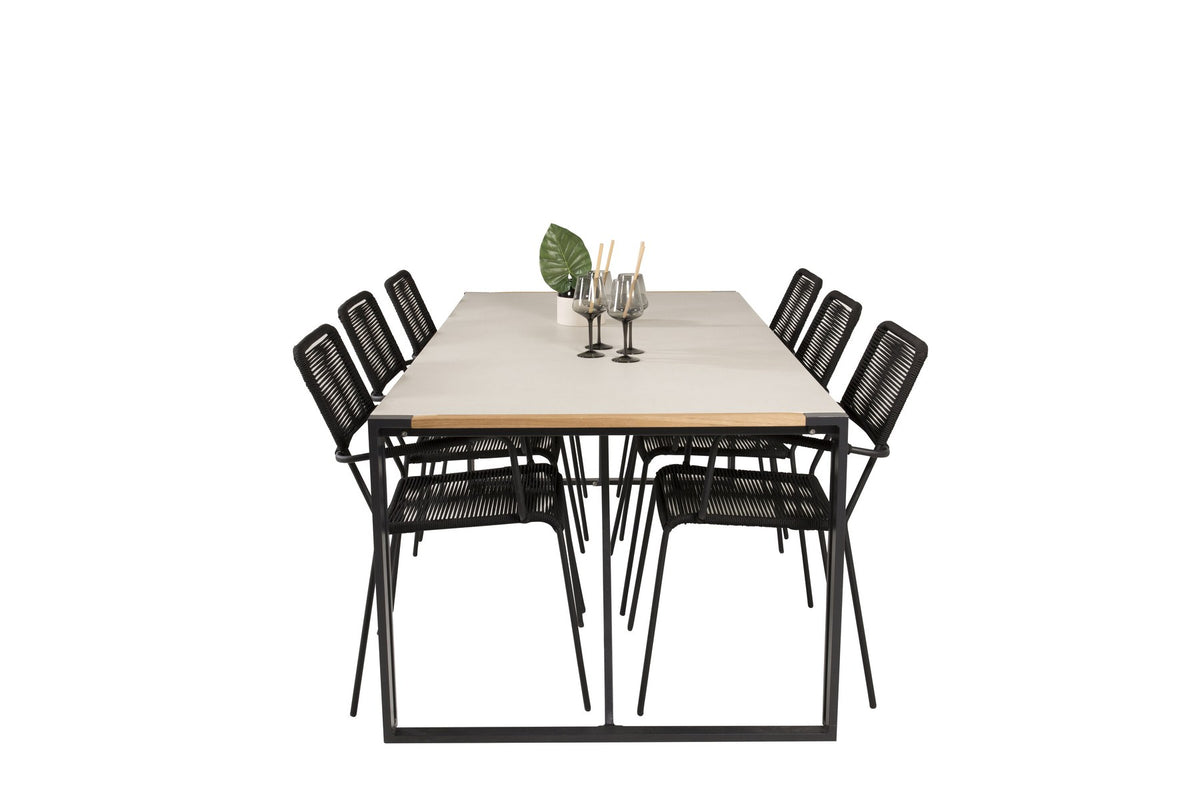 Zwei schwarze Esszimmerstühle mit geflochtener Seilsitzfläche und Aluminiumgestell neben rechteckigem Esstisch mit Glas-Teak-Platte und Stahlbeinen.