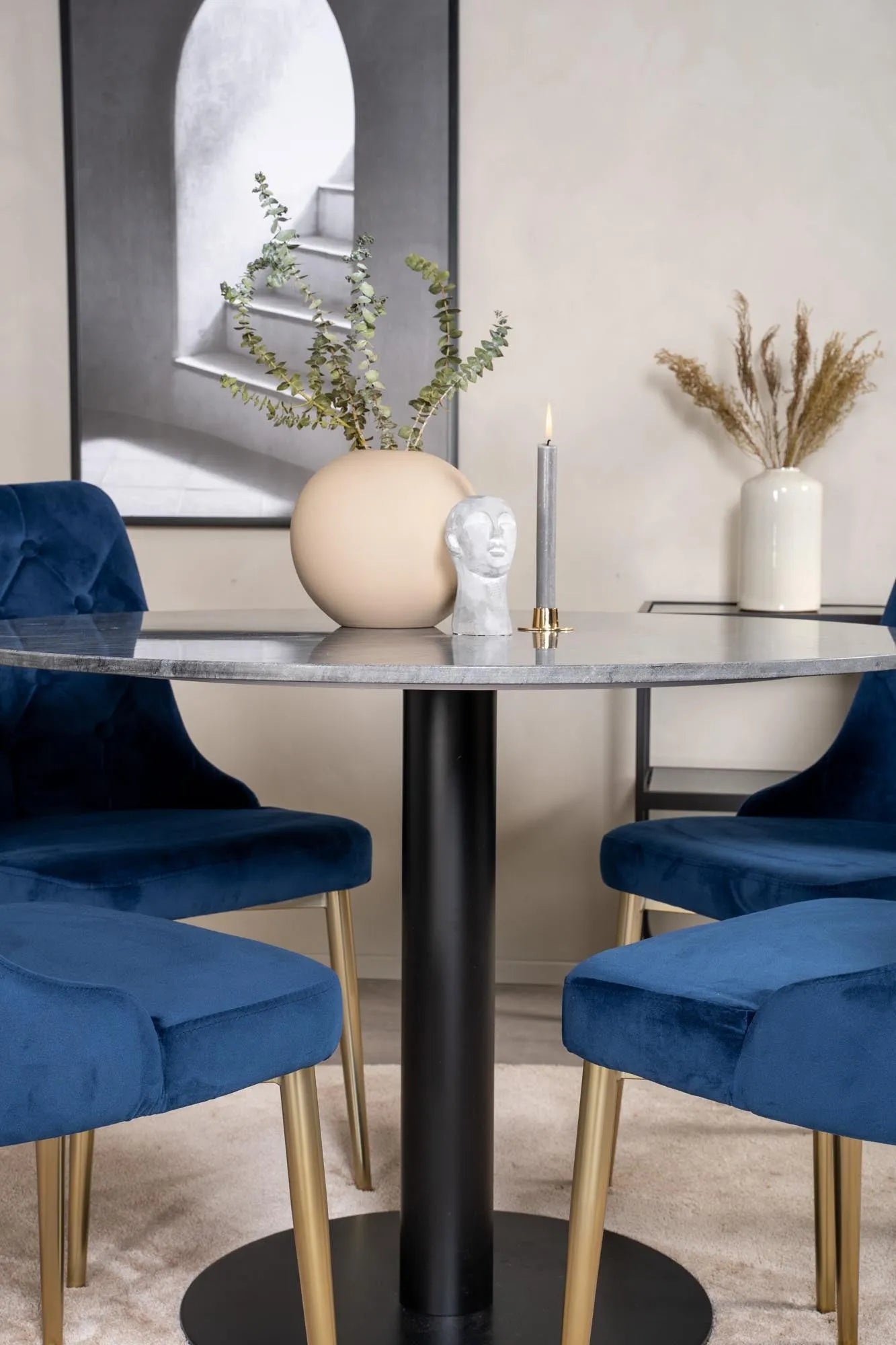Luxuriöses Esszimmerset mit rundem Tisch und vier Samtstühlen.