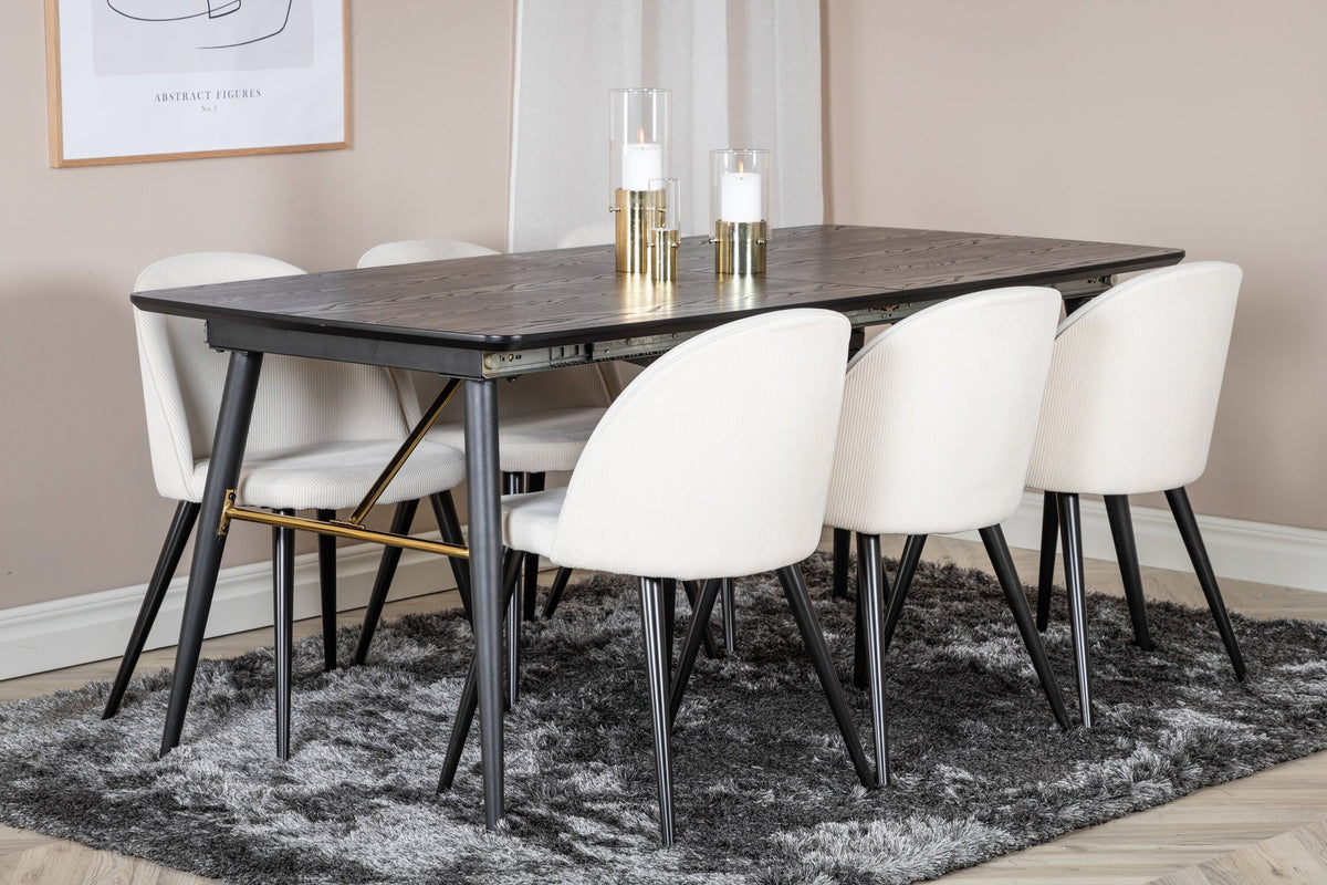 Rechteckiger Esstisch mit schwarzer MDF-Platte und Stahlbeinen, daneben zwei gepolsterte Esszimmerstühle in Creme mit Stahlgestell.