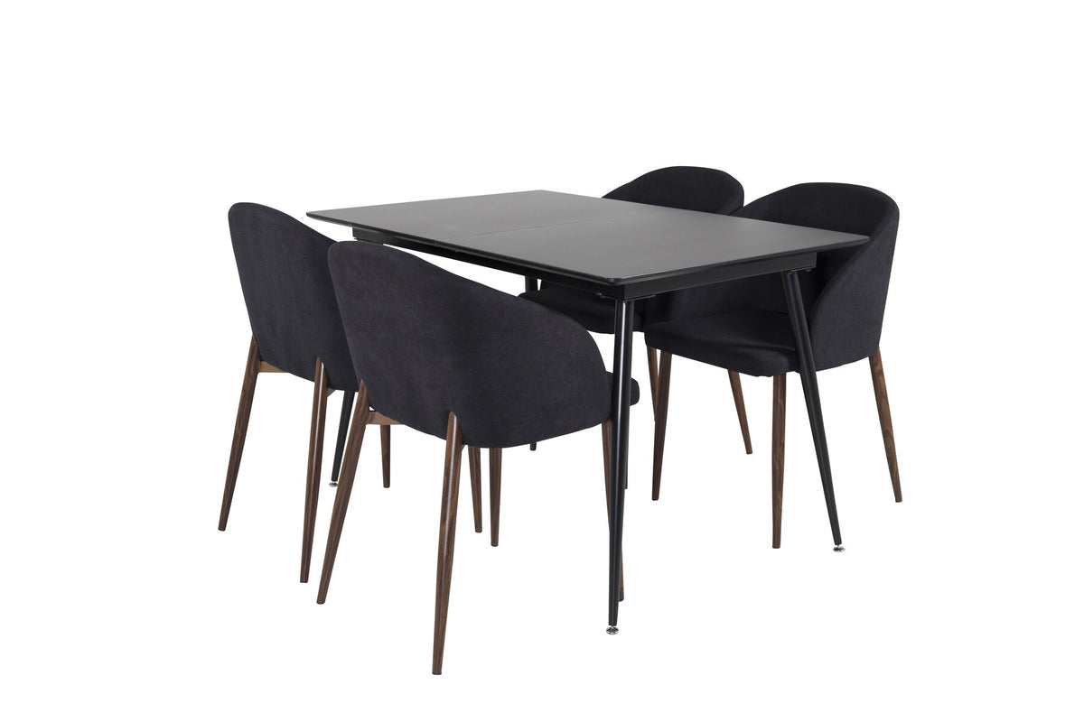 Rechteckiger Esstisch aus MDF und Stahl in Schwarz mit ausziehbarer Platte, daneben zwei Stühle mit Walnussbeinen und schwarzem Stoffbezug.