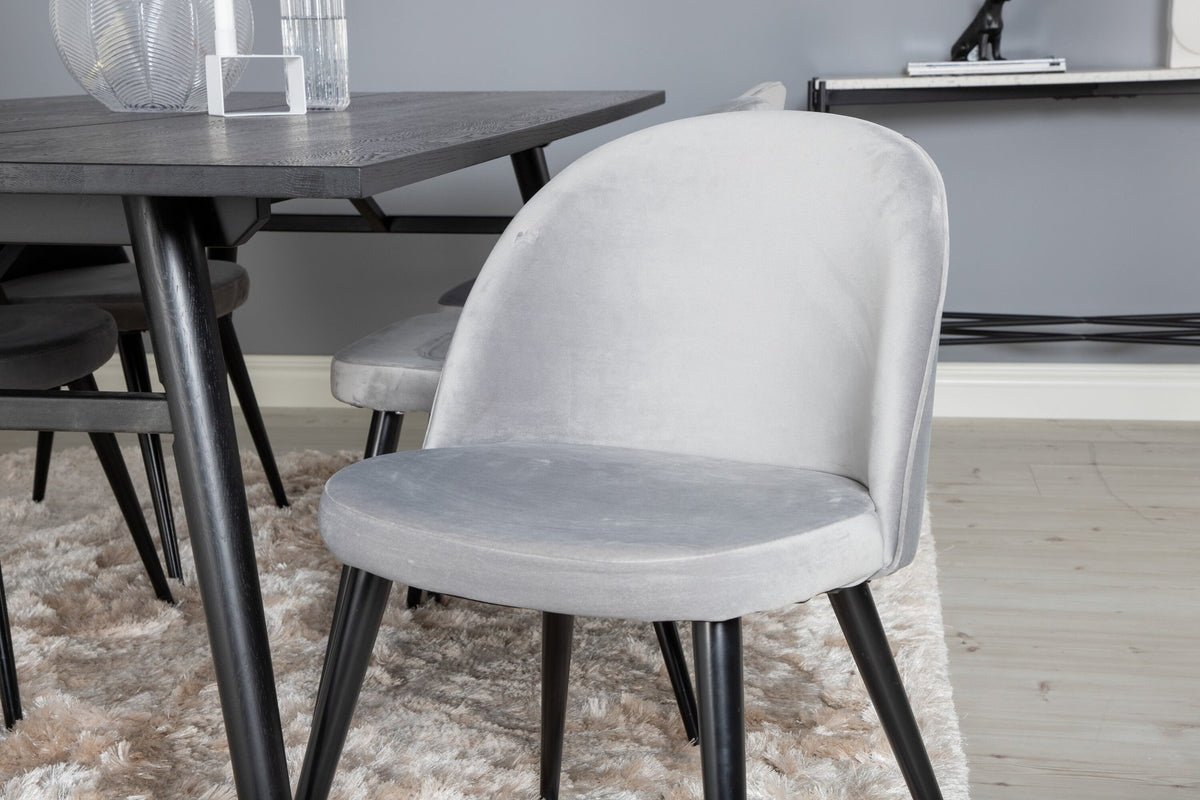 Rechteckiger Esstisch mit schwarzer Eichenplatte und Stahlbeinen, dazu zwei graue Stühle mit Stahlgestell aus dem Sleek & Velvet Set.