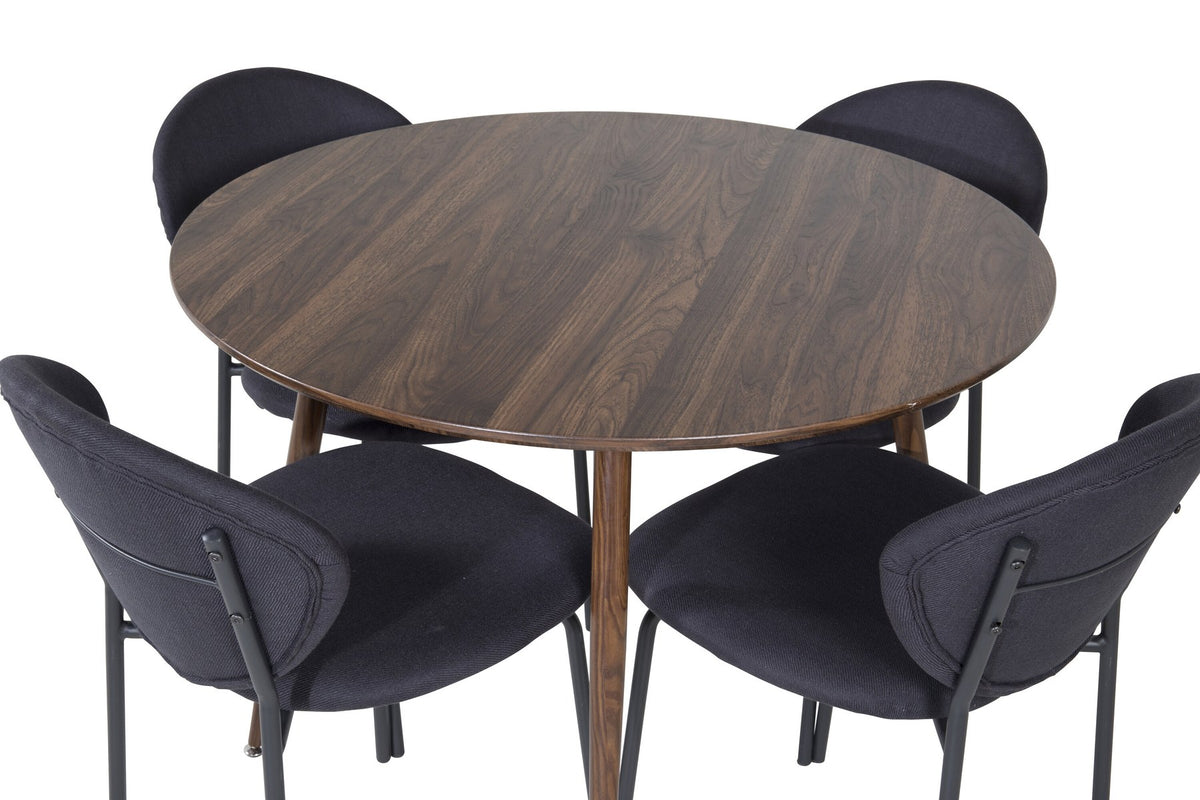 Zwei schwarze Esszimmerstühle aus MDF und Stahl neben einem runden Esstisch mit Nussbaum-Tischplatte, Durchmesser 100 cm.