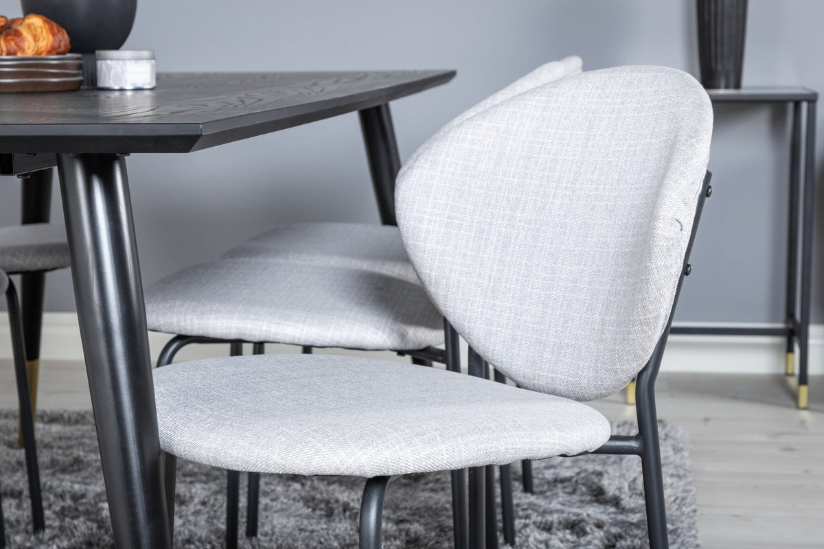 Schwarzes Esszimmerset Dipp mit Vault Stühlen: Tisch mit MDF-Furnierplatte und Stahlbeinen, Stühle mit Polsterbezug und Stahlgestell.