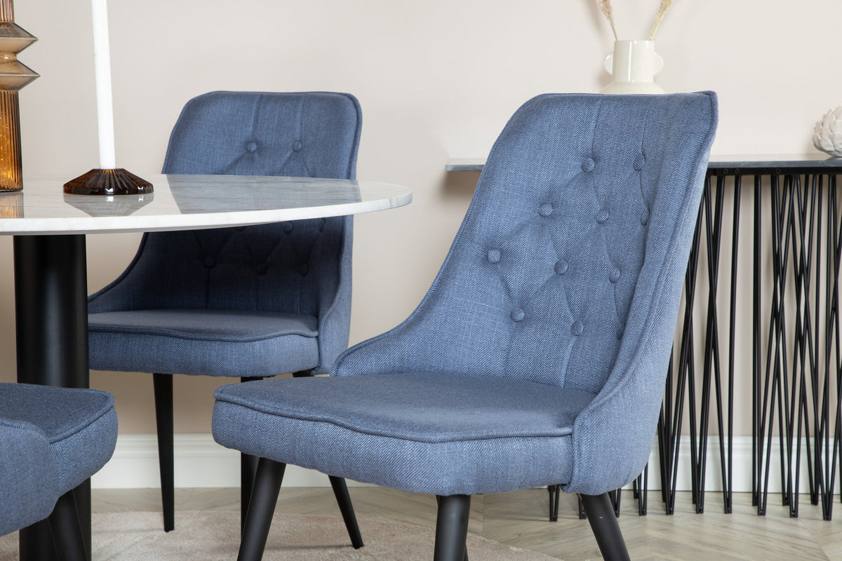 Runder Esstisch mit weisser Marmorplatte und Stahlbeinen, daneben zwei gepolsterte Stühle in Blau mit schwarzem Metallgestell.