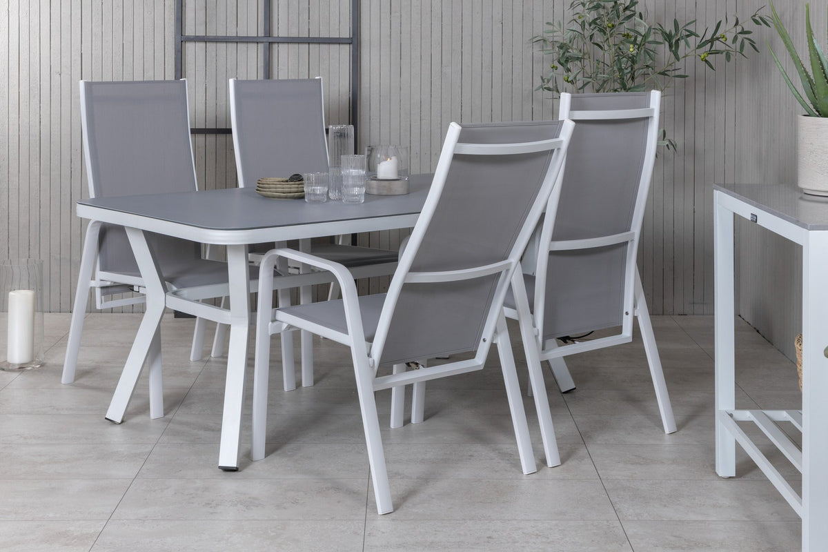 Rechteckiger Esstisch mit grauem Gestell und schwarzer Mattglas-Tischplatte, daneben zwei graue Relaxsessel aus Textilene mit Aluminiumbeinen.