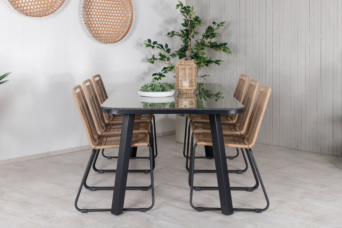 Gartentischset Paola mit schwarzem Stahlgestell und Weidengeflecht-Tischplatte sowie sechs stapelbaren Lindos-Stühlen aus schwarzem Aluminium und Polyesterseil.