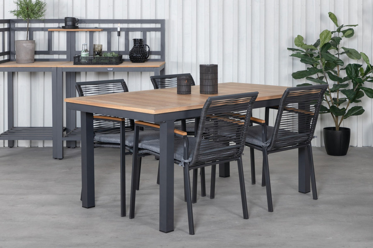 Zwei schwarze Aluminium-Stühle mit Polyester-Bezug und ein rechteckiger, ausziehbarer Teak-Tisch mit schwarzer Tischplatte.