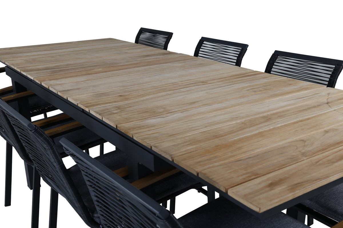 Foto eines schwarzen 2er-Stuhlsets mit Aluminiumgestell und Polyesterbezug neben einem rechteckigen Teak-Esstisch in Natur mit Stahlbeinen.