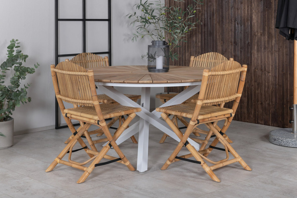 Runder Esstisch ⌀140 aus Teakholz mit Rattanbeinen neben Caféstuhl mit Aluminiumgestell und Bezug aus Baumwolle und Polyester in Naturfarbe.