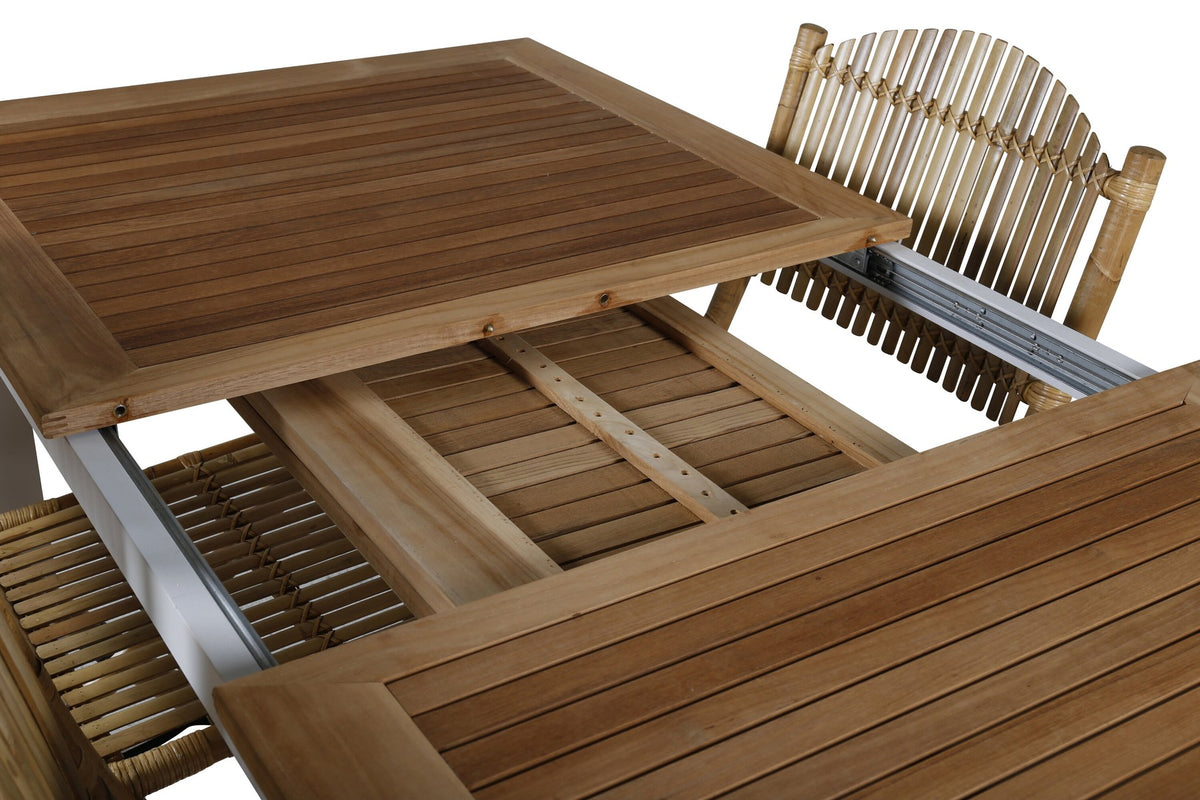Foto zeigt einen Cafe Stuhl mit Rattan-Beinen und Stoffbezug in Natur sowie einen rechteckigen Teakholz-Esstisch mit weissem Aluminiumgestell.