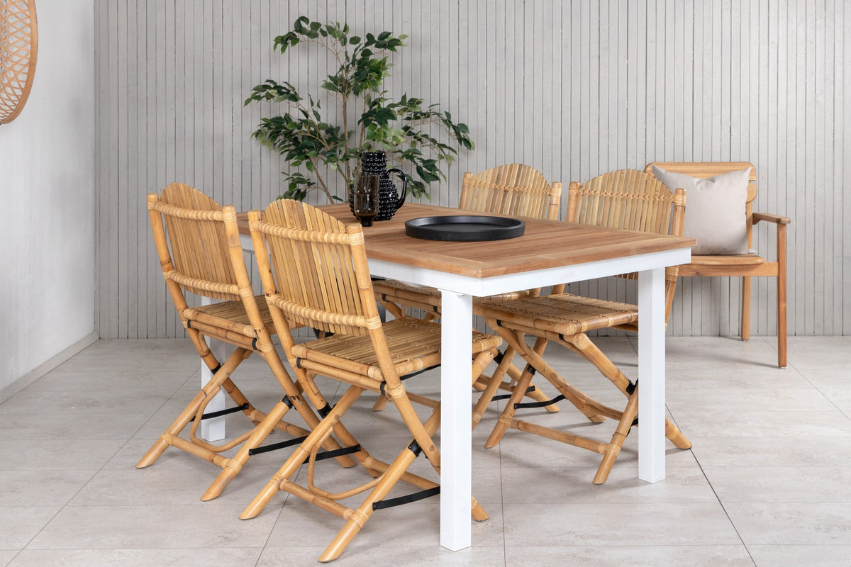 Foto zeigt einen Cafe Stuhl mit Rattan-Beinen und Stoffbezug in Natur sowie einen rechteckigen Teakholz-Esstisch mit weissem Aluminiumgestell.