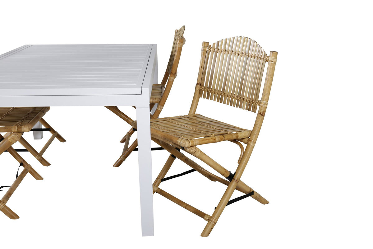 Aluminium-Caféstuhl in Natur mit Baumwoll-Polyester-Bezug neben rechteckigem Esstisch mit weisser Aluminium-Tischplatte und Rattanbeinen.