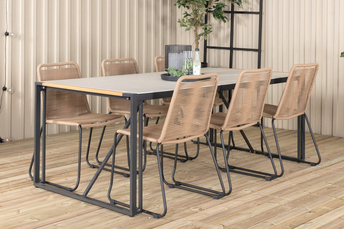Zwei braune Esszimmerstühle mit Teakholz und Aluminium neben einem rechteckigen Glastisch mit schwarzer Tischplatte und Stahlbeinen im Aussenbereich.