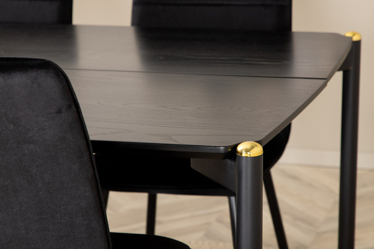 Esszimmerset Pelle mit schwarzem MDF-Tisch mit Furnier und sechs Windu Stühlen aus schwarzem Samt mit Metallgestell und Kissen.