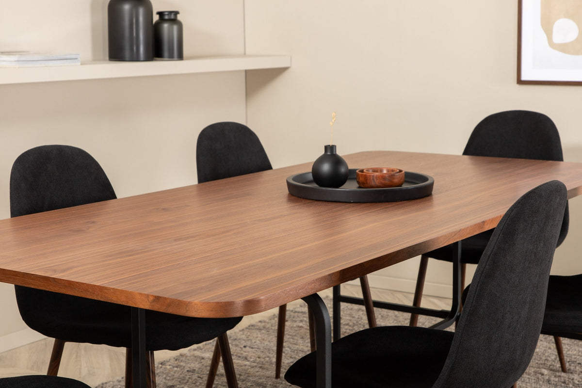 Rechteckiger Esstisch mit Nussbaum-Furnierplatte aus MDF und schwarzem Stahluntergestell, umgeben von sechs gepolsterten Polar Stühlen mit schwarzem Polyesterbezug.