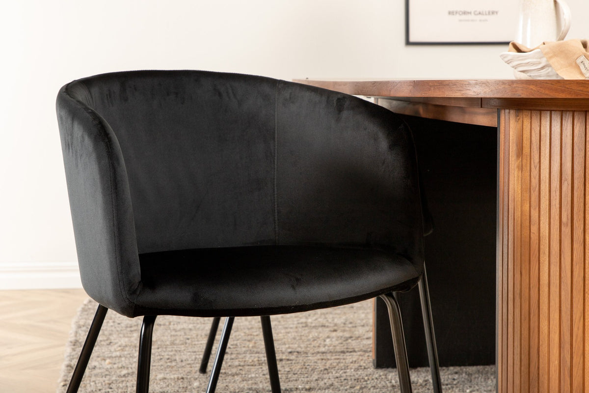 Ovaler Esstisch aus Nussbaum-MDF mit Furnier und vier schwarzen Esszimmerstühlen mit Samtsitz und schmalen Eisenbeinen von Venture Home.