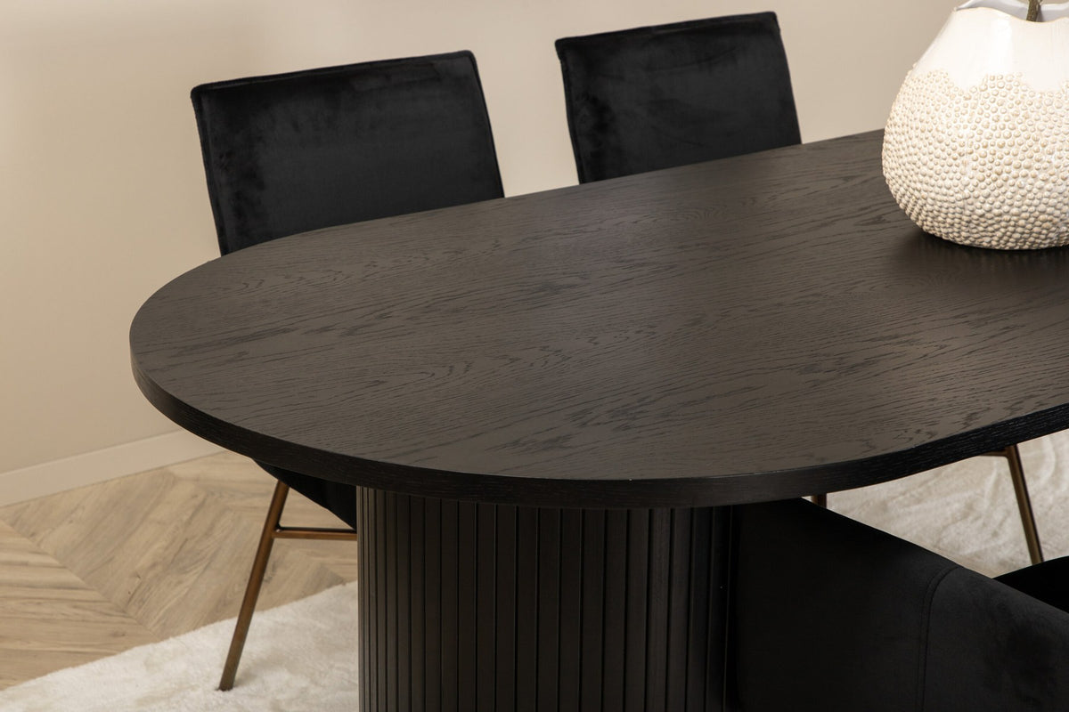 Ovaler Esstisch 200x90 cm aus MDF mit schwarzem Furnier und vier Esszimmerstühle mit kupferfarbenen Beinen und schwarzem Samtbezug.