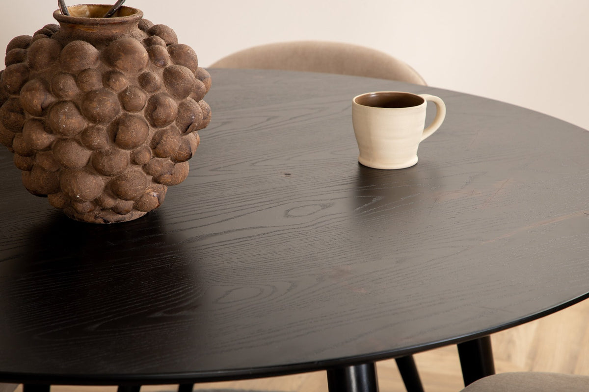 Rundes Dipp Esszimmerset: Esstisch ⌀115 cm mit schwarzem Furnier und schwarzen Beinen, dazu vier Velvet-Stühle mit schwarz-grauem Mikrofaserbezug.