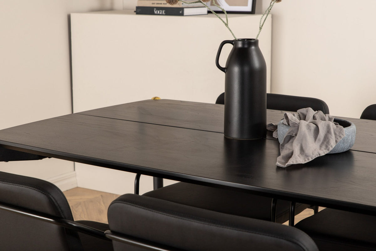 Schwarzer Esstisch aus MDF mit Furnier und Eisenbeinen, kombiniert mit sechs Stühlen aus Kunstleder und schwarzem Metallgestell.