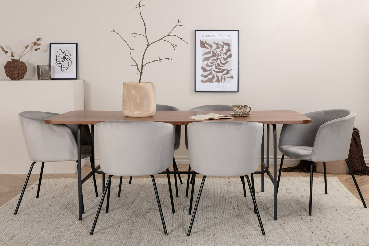 Esstisch mit Platte aus MDF und Walnussfurnier, schwarzem Metallgestell, kombiniert mit sechs Berit-Stühlen aus beigem Samtstoff und schwarzen Beinen.