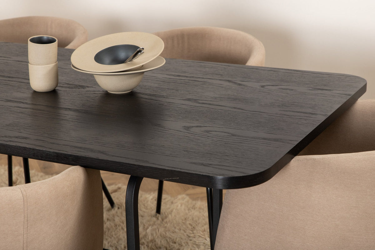 Esszimmerset Uno mit schwarzer MDF-Tischplatte und Metallgestell, kombiniert mit sechs Berit-Stühlen in Beige mit schwarzen Eisenbeinen.