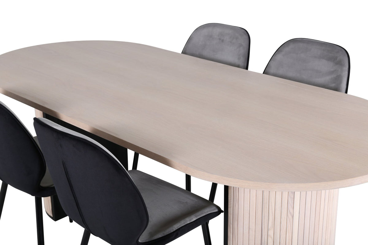 Zwei graue Esszimmerstühle mit Eisenbeinen und ovaler Esstisch mit MDF-Platte in Whitewash, Design von Venture Home.