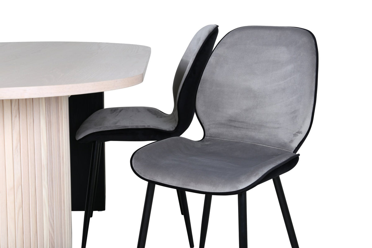 Zwei graue Esszimmerstühle mit Eisenbeinen und ovaler Esstisch mit MDF-Platte in Whitewash, Design von Venture Home.