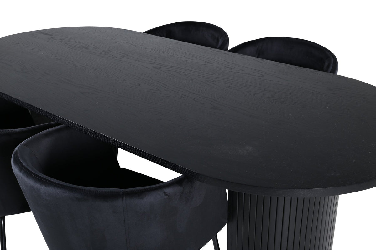 Schwarzes Esszimmerset aus MDF mit ovalem Esstisch und vier Stühlen mit Samtsitz und schlankem Eisengestell, Ansicht von vorne.