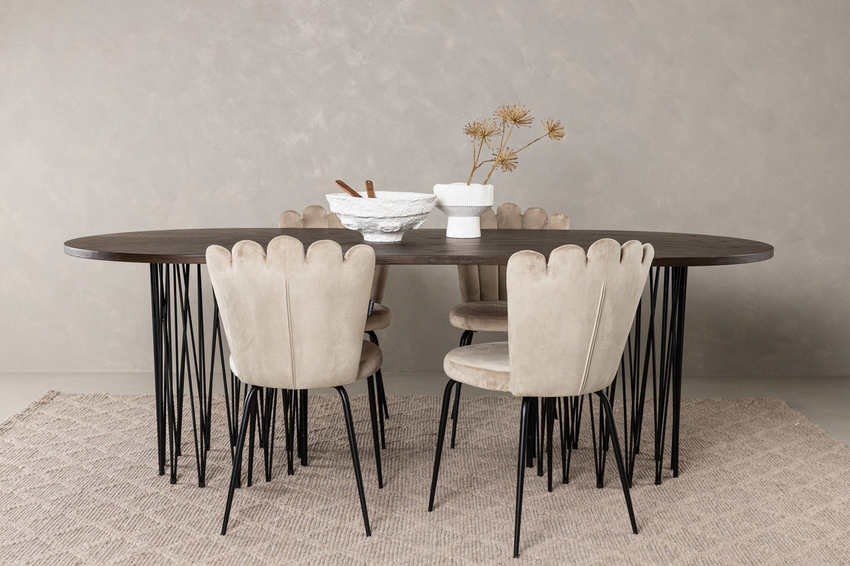 Ovaler Esstisch mit Tischplatte aus MDF mit Mocca-Furnier und schwarzem Metallgestell, umgeben von vier Limhamn-Stühlen mit beigem Samtbezug.
